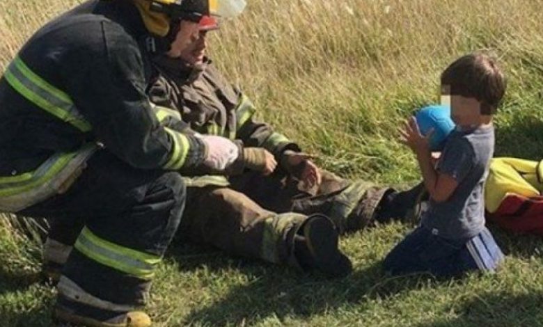 Conmovedora imagen de dos bomberos que distraen a un nene tras un accidente